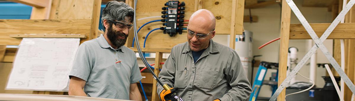 Two men work together inside a Pima facility